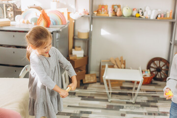 Happy smiling adorable girl playing together with wooden eco toys. Friendship,children activity