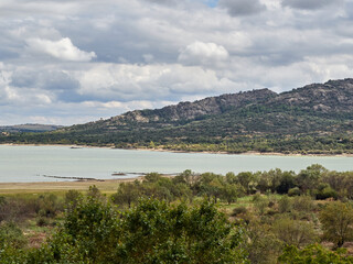 Fototapeta premium Landscape of Santillana reservoir, a lake in Manzanares el Real in a cloudy day. It is part of Parque Regional de la Cuenca Alta del Manzanares. Community of Madrid, Spain. Europe