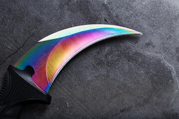 A dagger with a steel blade with a gradient color on a black background.