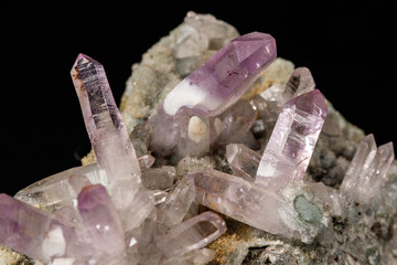 Macro mineral stone Amethyst crystals in rock on a black background