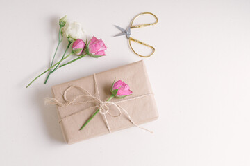 Gift box and small branches of pink roses. Handmade gift for Woman's Day or Mother's Day