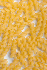 Top view of raw fusilli pasta, on a white background