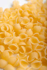 Close up of raw shell pasta background. Uncooked Italian conchiglie on a white background