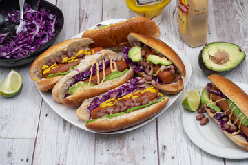 Vegan hot dogs made with carrot served in buns with beans, avocado and pickles