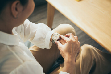 fashionable wearing stylish looking at luxury watch on hand check the time at workplace.concept for...