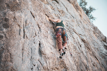 a girl climbing a rock in the open air.