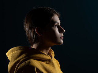 A confident look into the future, a concept. Young Caucasian woman, side view illuminated...