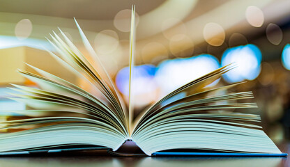 An open hardcover book on a table in a public library
