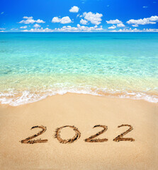 Fototapeta na wymiar 2022 written on sandy beach