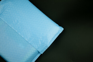 Blue padded envelopes with bubble wrap on black background.