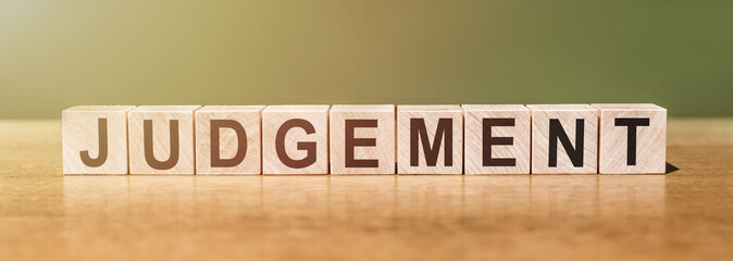 judgement word written on wood blocks on a green-brown background