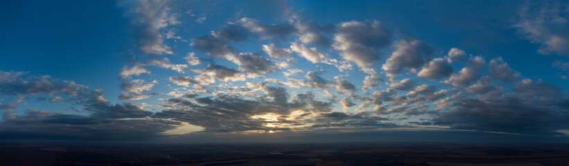 Panorama of sunset and cloudy sky. Natural celestial landscape.