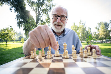 Group of senior friends playing chess at the park