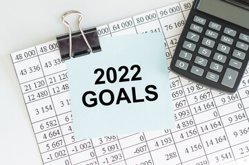 2022 goals inscription on the card, which on the clip is attached to the accountant sheet next to the calculator on the table