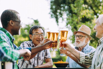 Group of senior friends drinking a beer at the park - Powered by Adobe