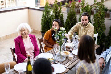 Family and friends celebrating at dinner on a rooftop terrace