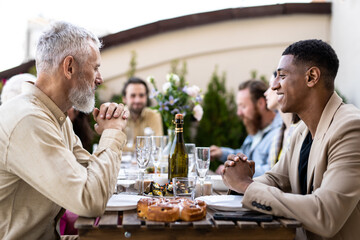 Family and friends celebrating at dinner on a rooftop terrace