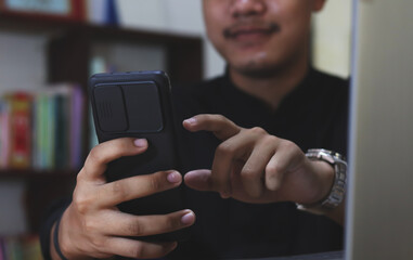 Hands of man using online virtual app on mobile phone. Millennial guy chatting on smartphone, using banking services, reading text message, typing, shopping, making call, browsing internet. Close up