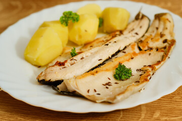 Trout filets with potatoes on plate