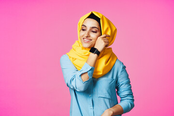 woman wearing yellow hijab electronic watch technology pink background
