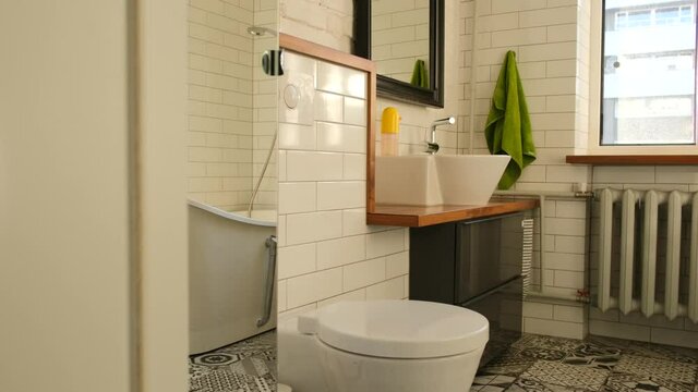 Bathroom interior with toilet bowl, mirror with bathtub sink and shower with window and heating radiator