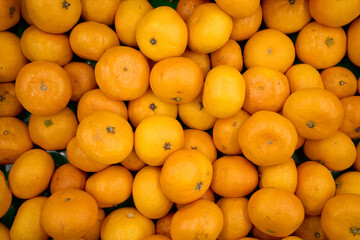 Tangerine background. Citrus fruit. Natural remedy for colds. Vegetarian food. Fresh mandarin oranges fruit or tangerines with leaves, as background.