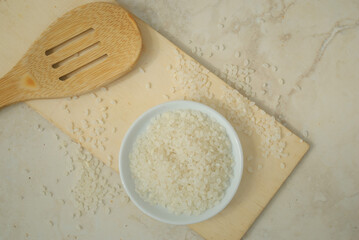 Rice  on a plate with wooden spoon in a kitchen top