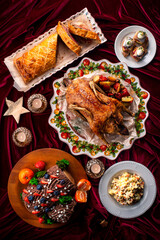 Delicious Christmas themed dinner table with roasted chicken, appetizers and desserts. Holiday concept.
