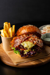 Close up of burger with cheese and bacon slice, fast food concept