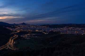 view of the city of Bilbao at sunset from a nearby mountain