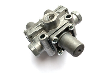 Protective valve of the triple pneumatic brake system of the truck on a white background. New spare parts.