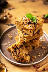 Pumpkin blondie bars with chocolate and walnuts closeup. Brownie pie slices in a plate on the dark culinary background. Baking for Thanksgiving	