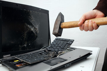 man destroyed laptop with a hammer. Nervous work, buggy computer, errors, slow Internet, not saved...