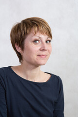 A young woman on a steep cliff by the river on a warm summer evening