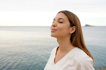 Portrait of relaxed woman on the beach breathing fresh air