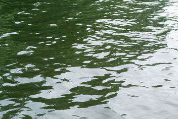 Clean green water background with sunlight reflection, green water texture