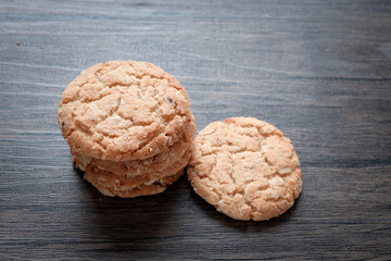 Delicious oatmeal cookies on dark wooden table.