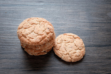Delicious oatmeal cookies on dark wooden table.
