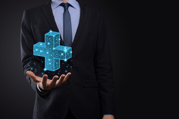 Businessman hand holding 3D plus low polygonal icon.Plus sign virtual means to offer positive thing...