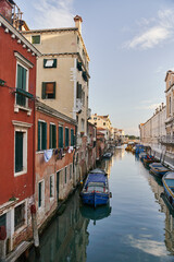 Fototapeta na wymiar Venice, Italy - 10.12.2021: Traditional canal street with gondolas and boats in Venice, Italy.