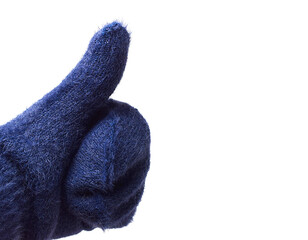 Hand in woolen blue mitten showing thumb up, isolated on white background. A positive gesture.