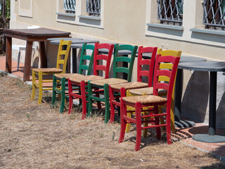 Group of Wooden and Colored Chairs side by side Outdoors and Stuffed