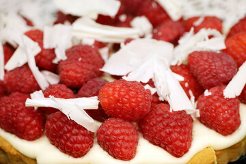 Raspberry pie with white grated chocolate, cream and fresh berries
