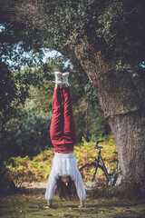 pretty young woman doing handstand in the forest