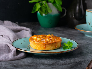 Delicious caramel mini tarts with nuts on dark background