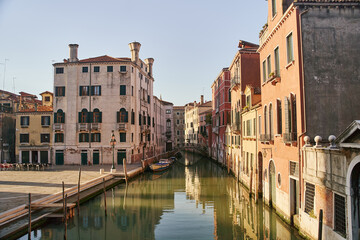 Fototapeta na wymiar Venice, Italy - 10.12.2021: Traditional canal street with gondolas and boats in Venice, Italy.