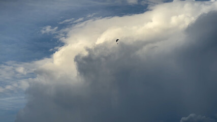 Hang Glider Flying among the Clouds