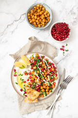 Vegetable salad with chickpeas, tahini sauce and pomegranate