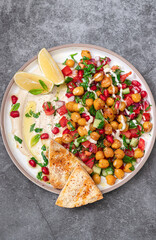 Vegetable salad with chickpeas, tahini sauce and pomegranate