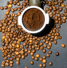 Ground coffee in a horn among aromatic beans. Home coffee making concept. Horizontal orientation. Top view. Close-up.